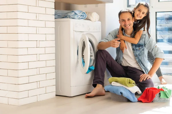 Ευτυχισμένη casual πολυεθνική οικογένεια ρούχα πλυντηρίου στο σπίτι — Φωτογραφία Αρχείου