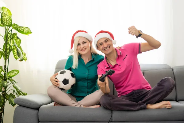 Joven pareja jugando video juego con joysticks en casa para Navidad — Foto de Stock