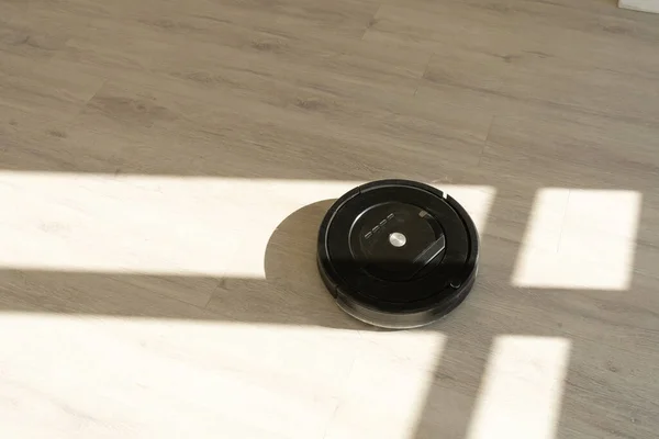 Роботизований пилосос на ламінованій дерев'яній підлозі у вітальні — стокове фото