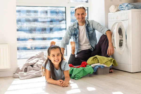 Feliz familia hombre padre cabeza de familia e hija niño en la lavandería con lavadora — Foto de Stock