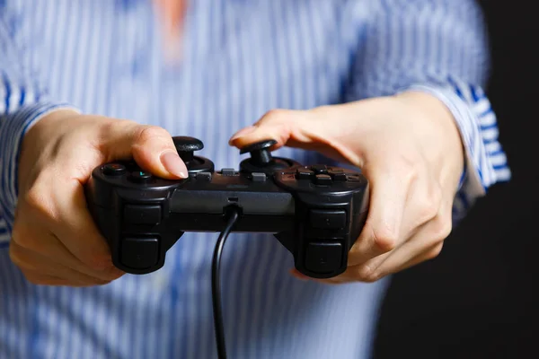 Mani femminili con un gamepad. Isolato su sfondo nero — Foto Stock