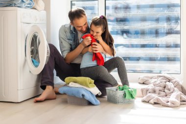 Mutlu çok ırklı aile çamaşırları evde.