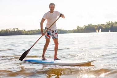 Gün batımında kürek çeken bir kürek çekme silueti.