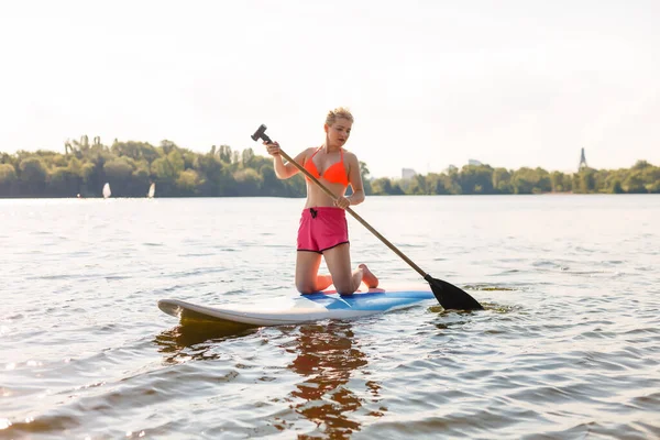 Una hermosa mujer practicando remo en un hermoso día soleado — Foto de Stock