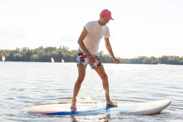 Silueta de stand up paddle boarder remando al atardecer —  Fotos de Stock