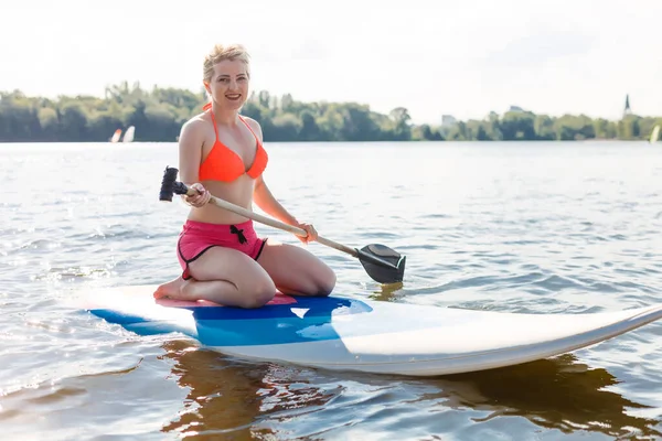 Молода приваблива жінка на дошці весла в озері, СУП — стокове фото
