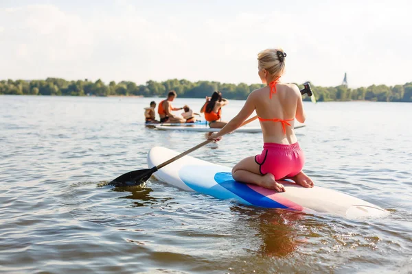 Jovem mulher atraente em pé paddle board no lago, SUP — Fotografia de Stock