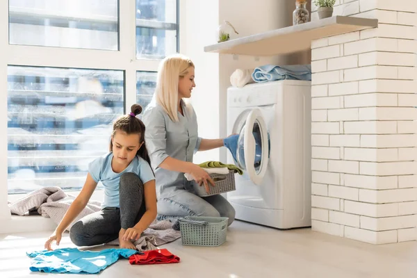 Ευτυχισμένη νοικοκυρά και η κόρη της με λινό κοντά στο πλυντήριο — Φωτογραφία Αρχείου