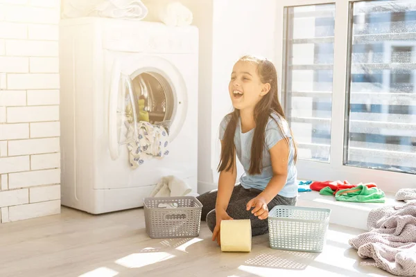 Çamaşır yıkayan küçük bir kız. Ev işi kavramı. — Stok fotoğraf