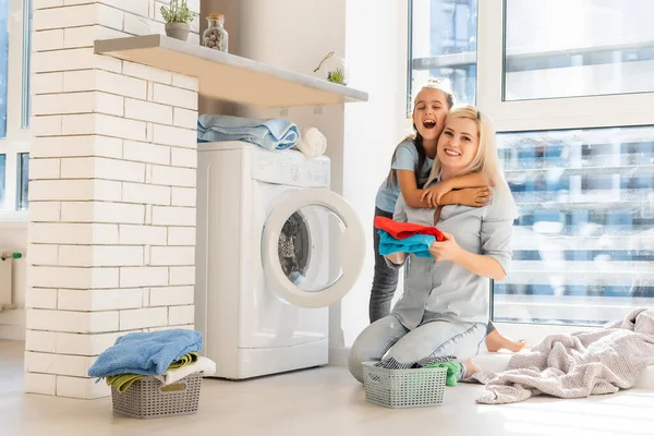 Fiatal háziasszony és kislány együtt mosnak. — Stock Fotó