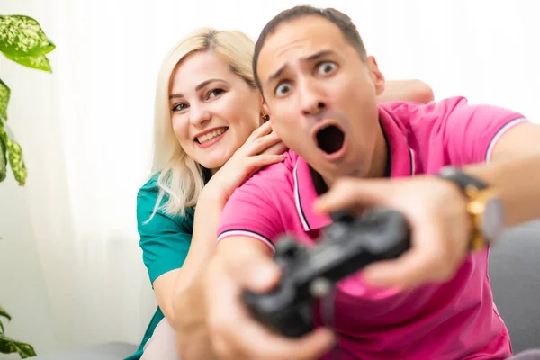 Mann und Frau spielen zu Hause Videospiele mit Joystick. — Stockfoto