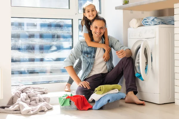 Ευτυχισμένη οικογένεια φορτώνει ρούχα στο πλυντήριο στο σπίτι — Φωτογραφία Αρχείου