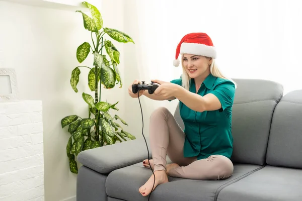 Frau spielt Videospiel auf dem Sofa im Zimmer, Neujahr und Weihnachten — Stockfoto