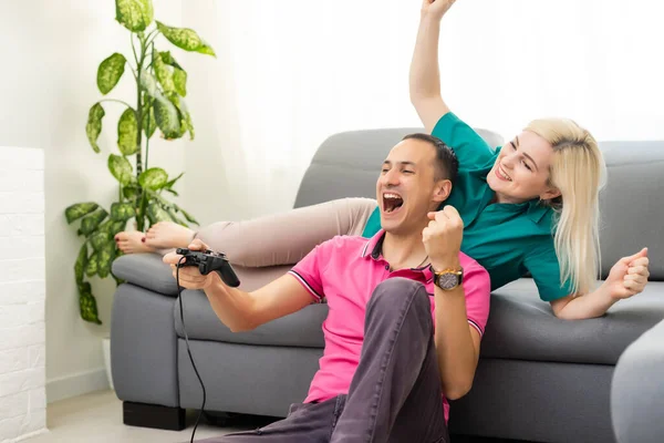 Man en vrouw spelen videospelletjes met joystick thuis. — Stockfoto