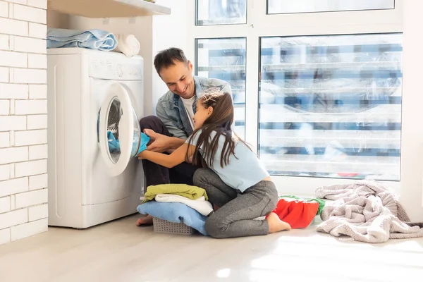 Happy Family nakládání oblečení do pračky doma — Stock fotografie