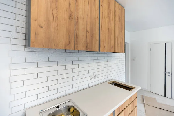 Нові встановлені дерев'яні кухонні шафи з сучасною декоративною нержавіючої сталі — стокове фото