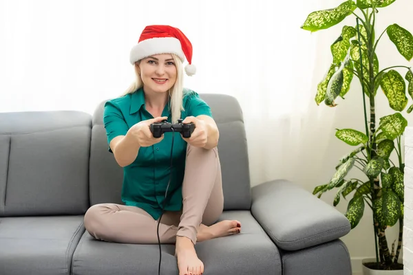 Weihnachten, Spiele, Urlaub, Feier und Technologiekonzept - Frau hält Gamepad in der Hand und spielt Videospiele zu Hause — Stockfoto