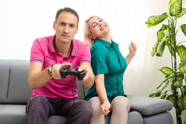 Man en vrouw spelen videospelletjes met joystick thuis. — Stockfoto