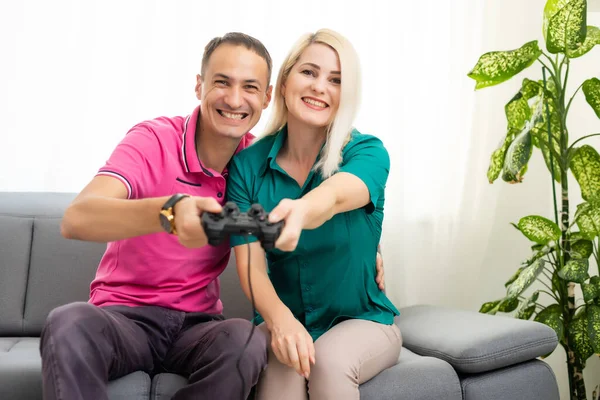 Hombre y mujer jugando videojuegos con joystick en casa. — Foto de Stock