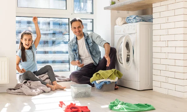 Šťastný ležérní multiethnic rodina prádelna oblečení doma — Stock fotografie