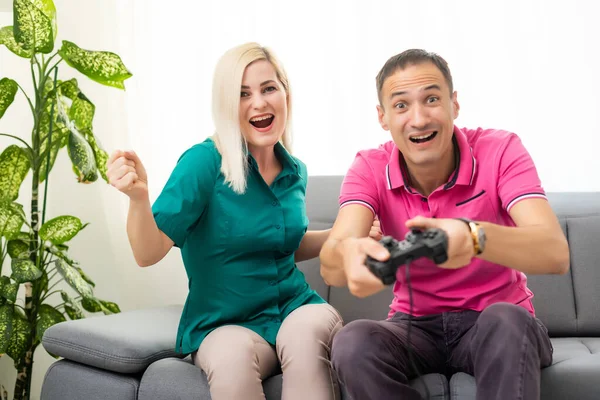 Mann und Frau spielen zu Hause Videospiele mit Joystick. — Stockfoto