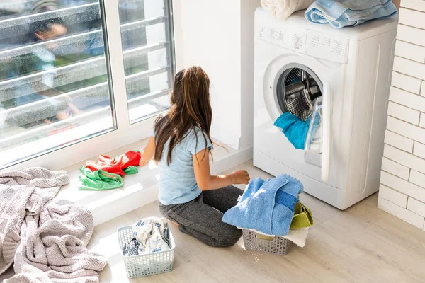 Menina feliz fazendo lavanderia em casa interior — Fotografia de Stock