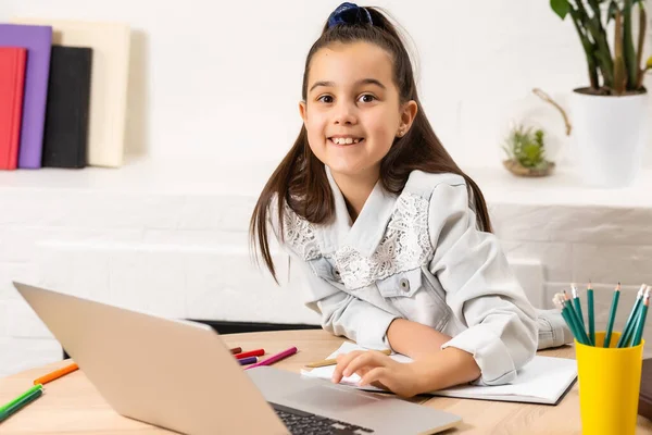 Estudiante niña de la escuela tarea en el ordenador portátil de plata — Foto de Stock