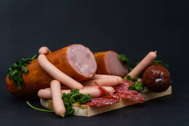Koyu arkaplanda farklı sosislerden oluşan bir kompozisyon.
