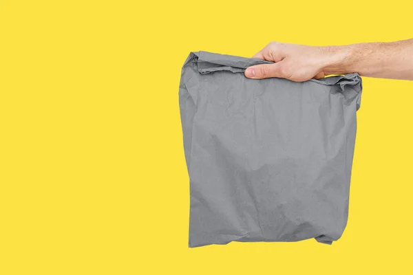 Pengiriman pria memegang tas kertas Trendy warna 2021 abu-abu dan kuning. — Stok Foto
