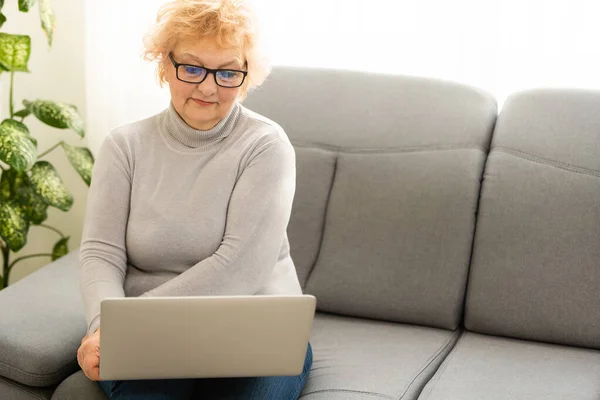 Videoanruf. Gut aussehende ältere Dame mit einem Videoanruf am Laptop — Stockfoto