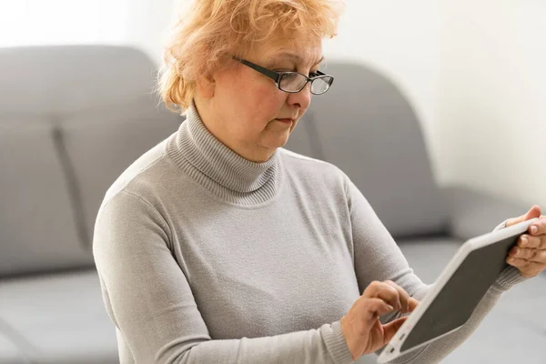 Elegante donna di mezza età utilizzando tablet pc a casa — Foto Stock