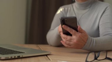 Yaşlı kadın elleri cep telefonu tutuyor. Üst sınıflar akıllı telefon kullanıyor. İletişim teknolojisi kavramı