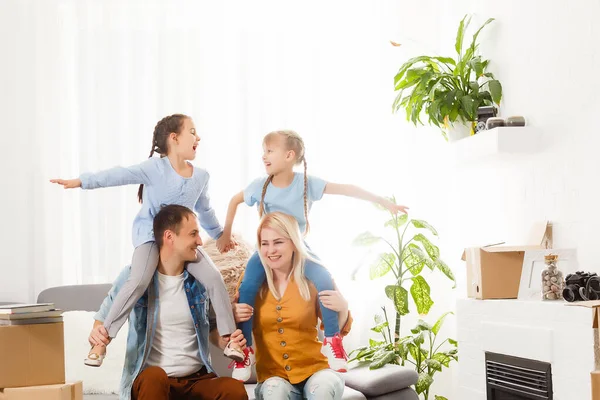 Famille heureuse avec des boîtes en carton dans une maison neuve au jour du déménagement. — Photo