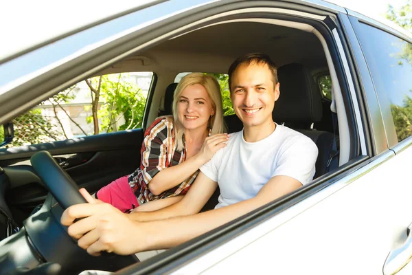 Gelukkige jongeman en vrouw in een auto genietend van een road trip op een zomerdag. — Stockfoto