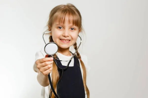 Petite écolière étudie la médecine avec phonendoscope, isolé sur blanc — Photo