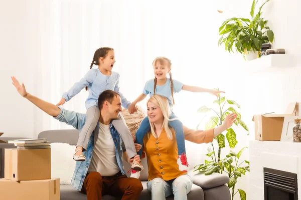 Lycklig familj flyttar hem med lådor runt — Stockfoto