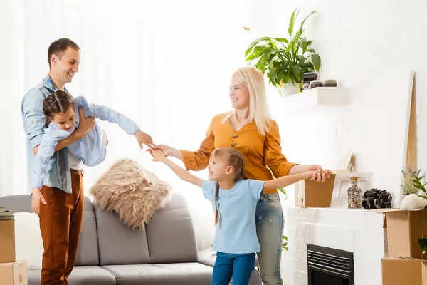 Familia feliz mudándose a casa con cajas alrededor — Foto de Stock