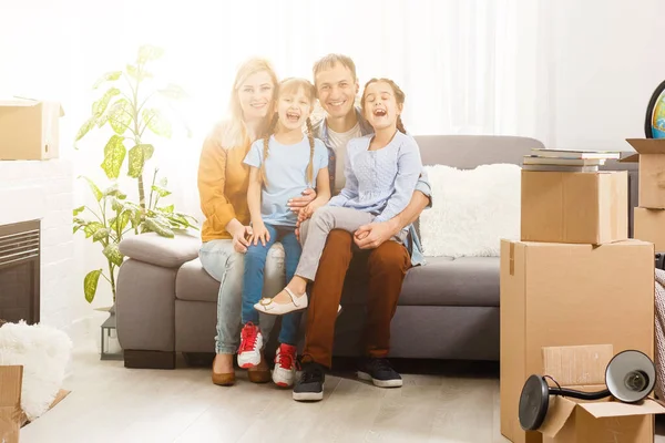 Glückliche Familie mit Kartons im neuen Haus am Umzugstag. — Stockfoto