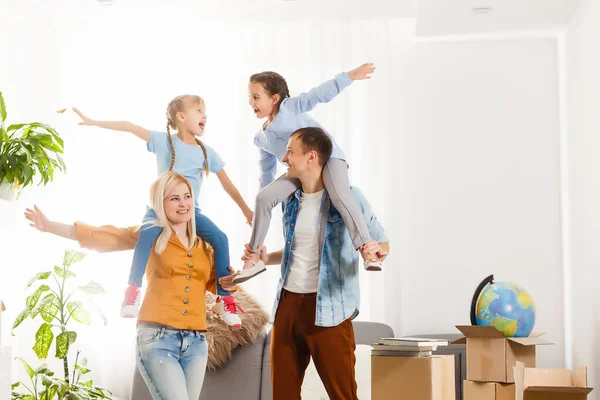 Happy family with cardboard boxes in new house at moving day. — Stock Photo, Image