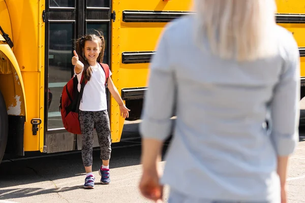 Madre llevando a su hija a la escuela, diciéndole adiós por el día — Foto de Stock