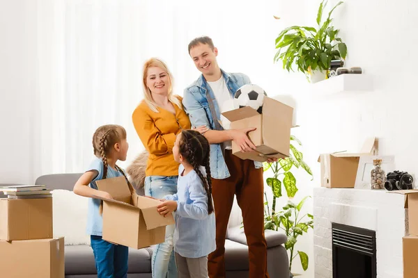 Rodzina z kartonowymi pudełkami stojąca w rzędzie w domu — Zdjęcie stockowe