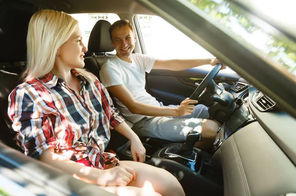 Feliz joven hombre y mujer en un coche disfrutando de un viaje por carretera en un día de verano. —  Fotos de Stock