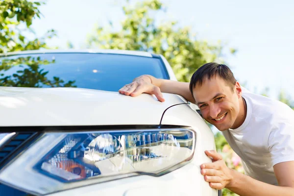 Muž objímající auto v prodejně aut — Stock fotografie