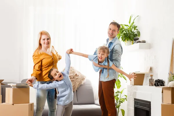 Famille heureuse avec des boîtes en carton dans une maison neuve au jour du déménagement. — Photo