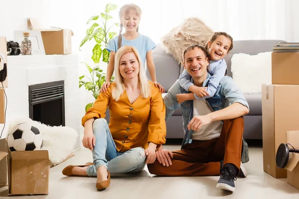 Boldog család költözik haza dobozokkal körülvéve. — Stock Fotó