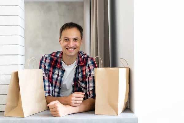 delivery, mail and people concept - happy man delivering food in disposable paper bag to customer home