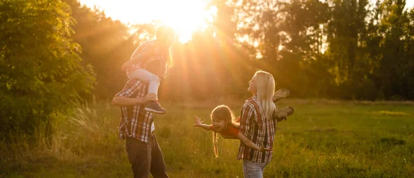 Szczęśliwa rodzina spacery w polu i patrząc na zachód słońca — Zdjęcie stockowe