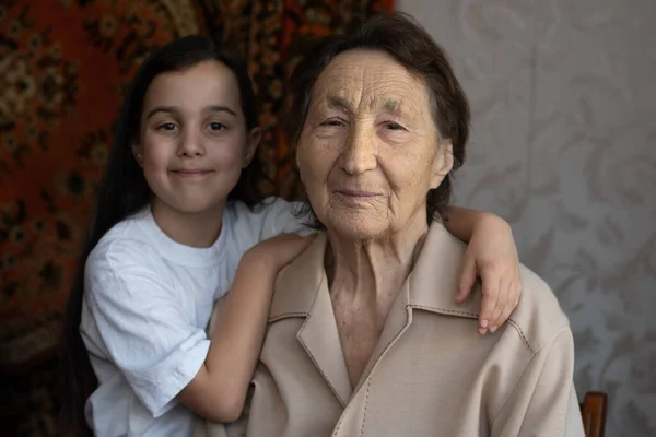 Little baby girl and very old woman. Little child hugging grandmother. Granddaughter — Stock Photo, Image