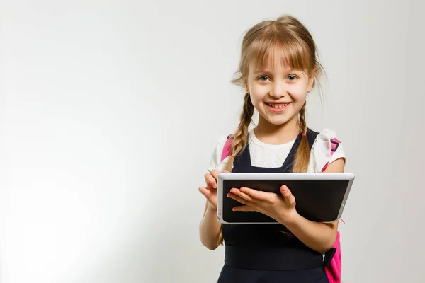 Liten blond skola flicka med ryggsäck väska porträtt isolerad på vit bakgrund — Stockfoto