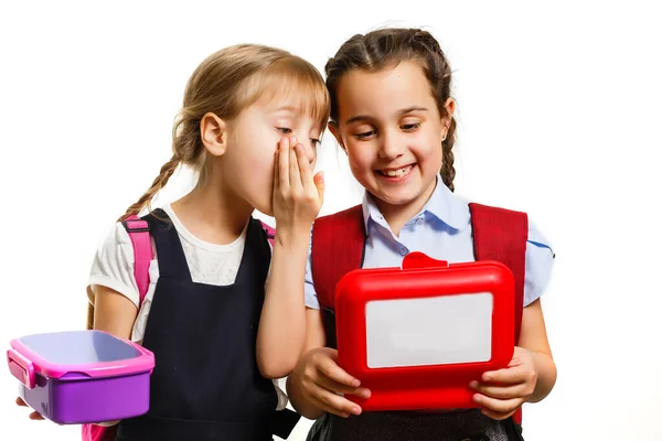 Pupils of primary school with lunch-boxes in hands. Girls with backpacks are eating fruit. Beginning of lessons. First day of fall. — Stock Photo, Image